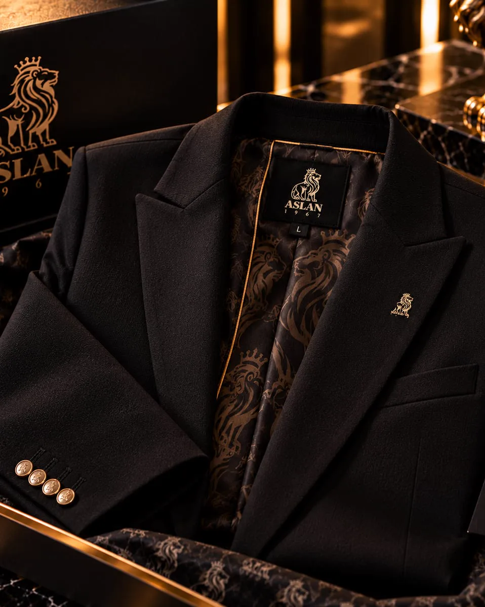 Veste de costume noire ASLAN 1967 posée dans son coffret, doublure imprimée de lions.